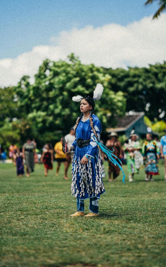 Native American woman participates in a powwow wearing a stunning traditional dress