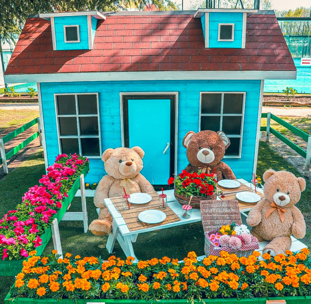 teddy bears in a garden with a custom-made house