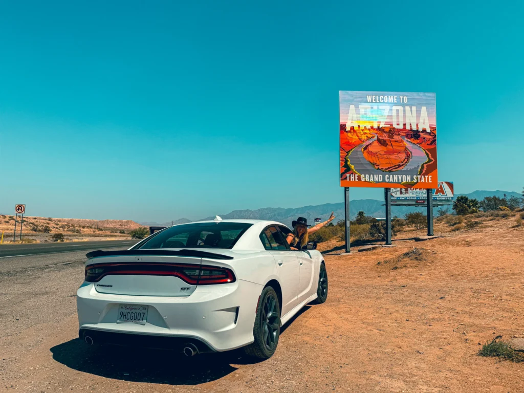 girl in a car smile in front of arizona sign